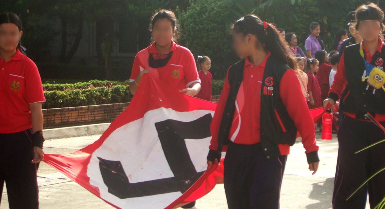A giant Nazi flag is carried by students along a street in the northern Thai city.