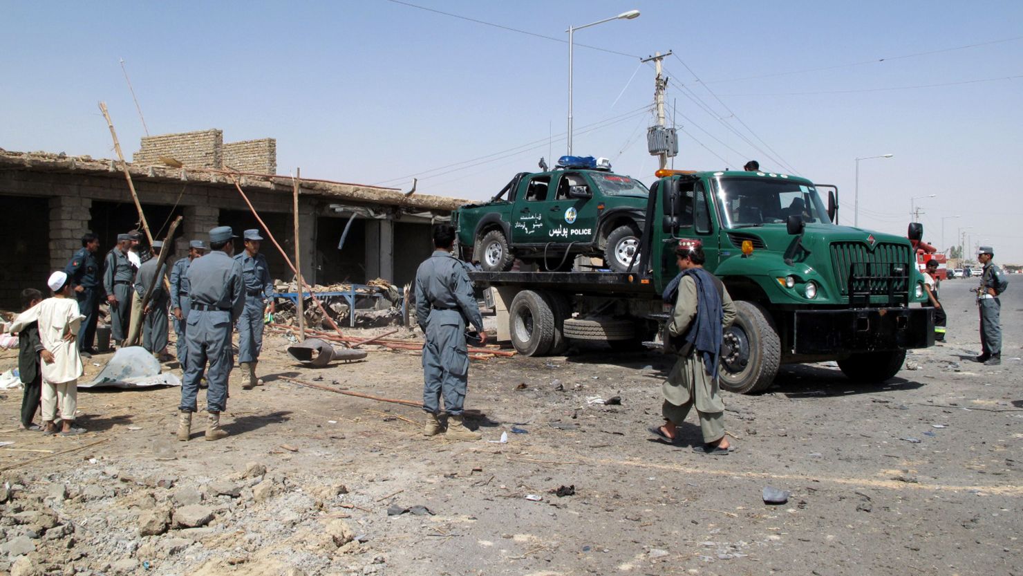 Members of Afghanistan National Police and security officials clear debris after the blast in Lashkar Gah.