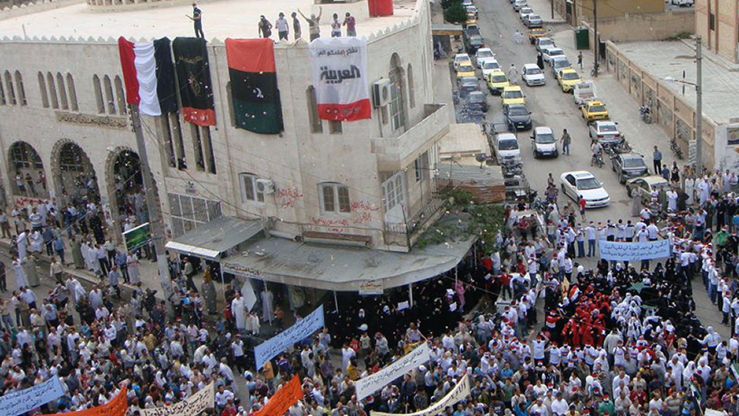 Anti-government protesters march in Idlib, Syria, on Friday, as more people were reported killed.