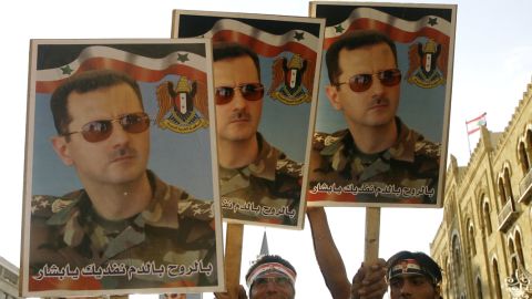 Syrian regime supporters carry pictures of President Bashar al-Assad in Beirut on September 8, 2011. 
