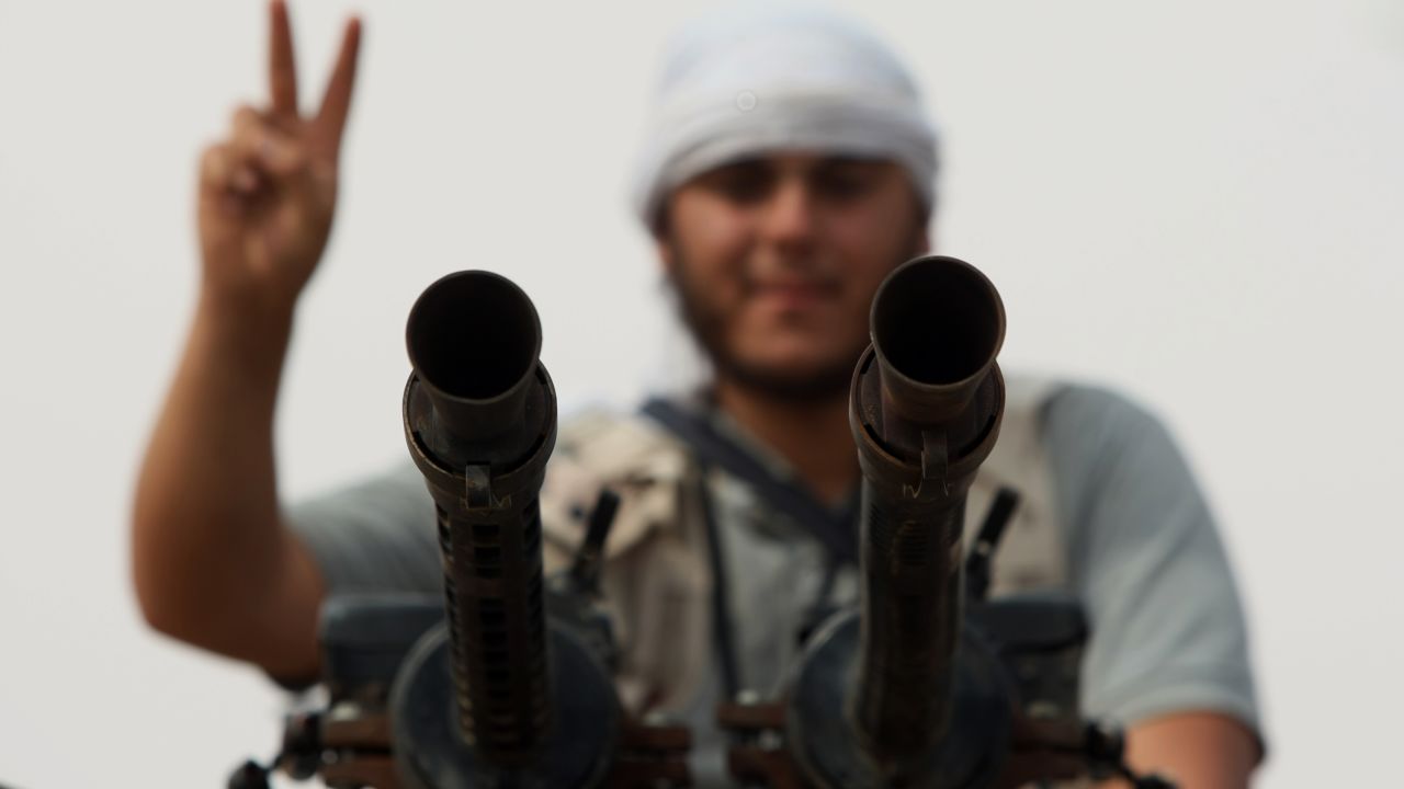 A National Transitional Council fighter flashes the V-sign as on the eastern front line of Sirte on October 2
