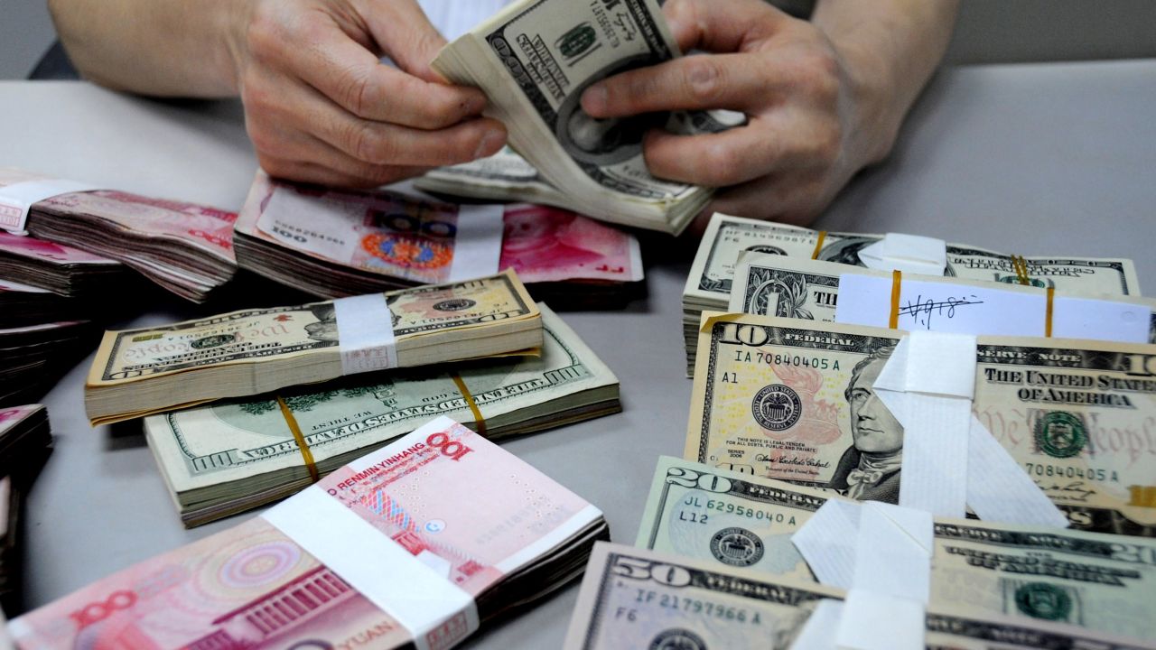 A staff member counts money at a branch of the Bank of China on August 10 in Lianyungang, Jiangsu Province of China.