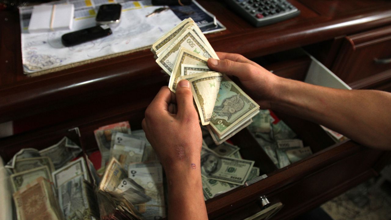 A man counts money at an exchange booth at the Buqayaa smugglers market on Lebanon's border with Syria.