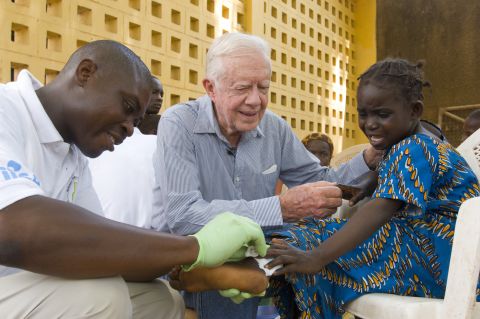 Former President Jimmy Carter with a child who has Guinea worm disease. 
