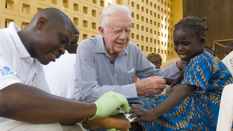 Former President Jimmy Carter with a child who has Guinea worm disease. 