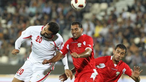 Iran's Mohammad Ghazi, left, leaps with Palestine midfielder Mali Kaware at Azadi Stadium on Wednesday.