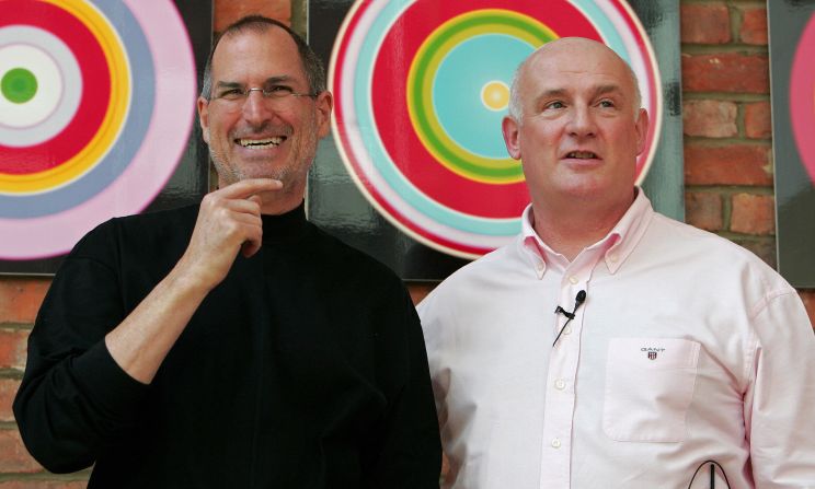 <a href="http://www.cnn.com/specials/tech/steve-jobs-the-man-in-the-machine">Jobs</a> laughs as he poses with Eric Nicoli, chief executive officer of EMI, while promoting a new partnership in London in April 2007. 