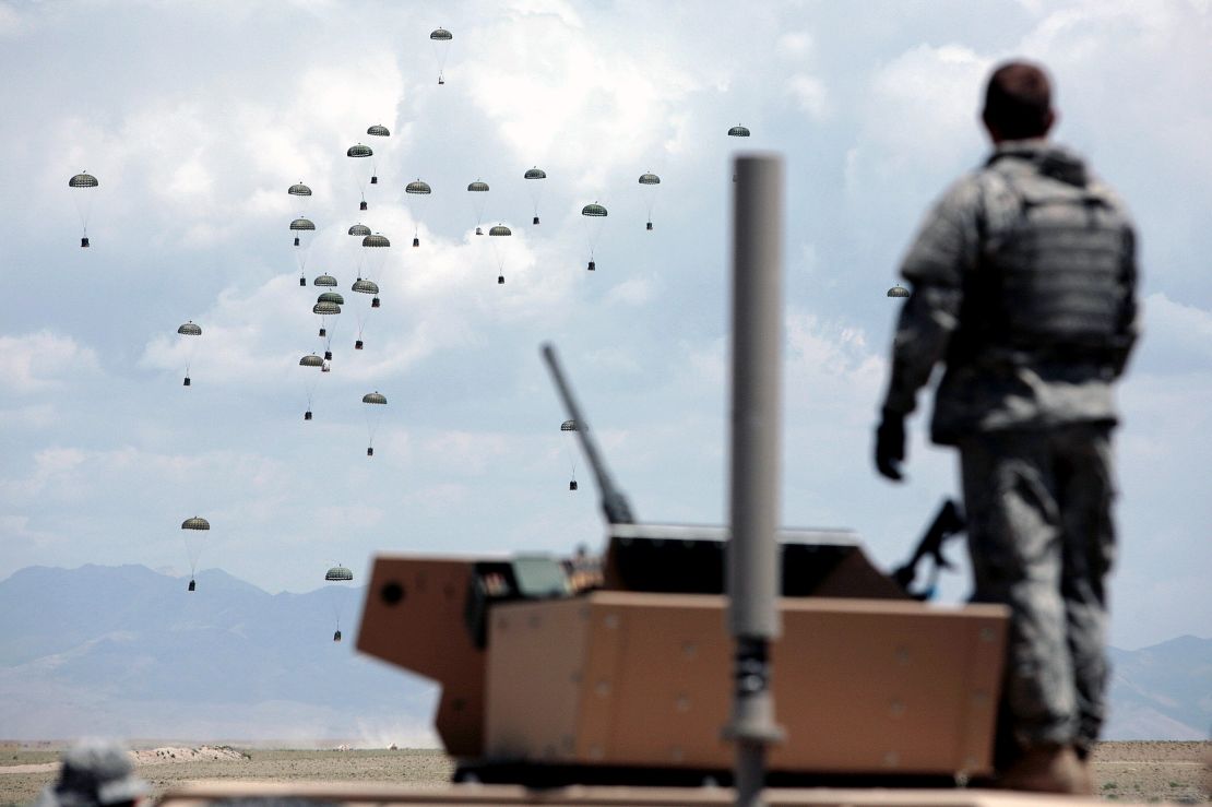A US soldier looks on as a C117 plane is drops food, water and other supplies at an undisclosed location in the Ghazni province of Afghanistan, May 2007.  