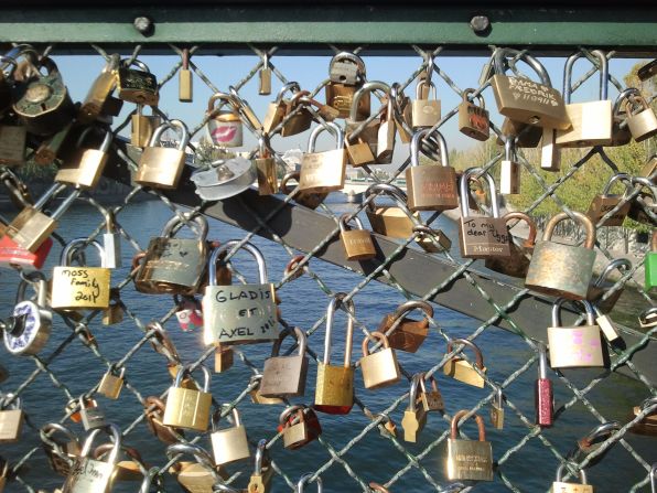Lovers leave locks inscribed with their names on Pont des Arts.
