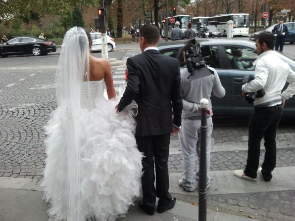 No limo needed: Newlyweds negotiate a Paris intersection after posing for photos on the Pont Alexandre III.