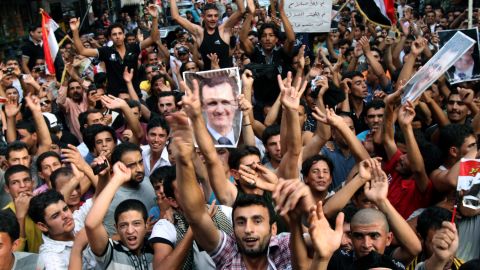 Syrian regime supporters carry pictures of President Bashar al-Assad during a protest in Beirut on 2 October. 