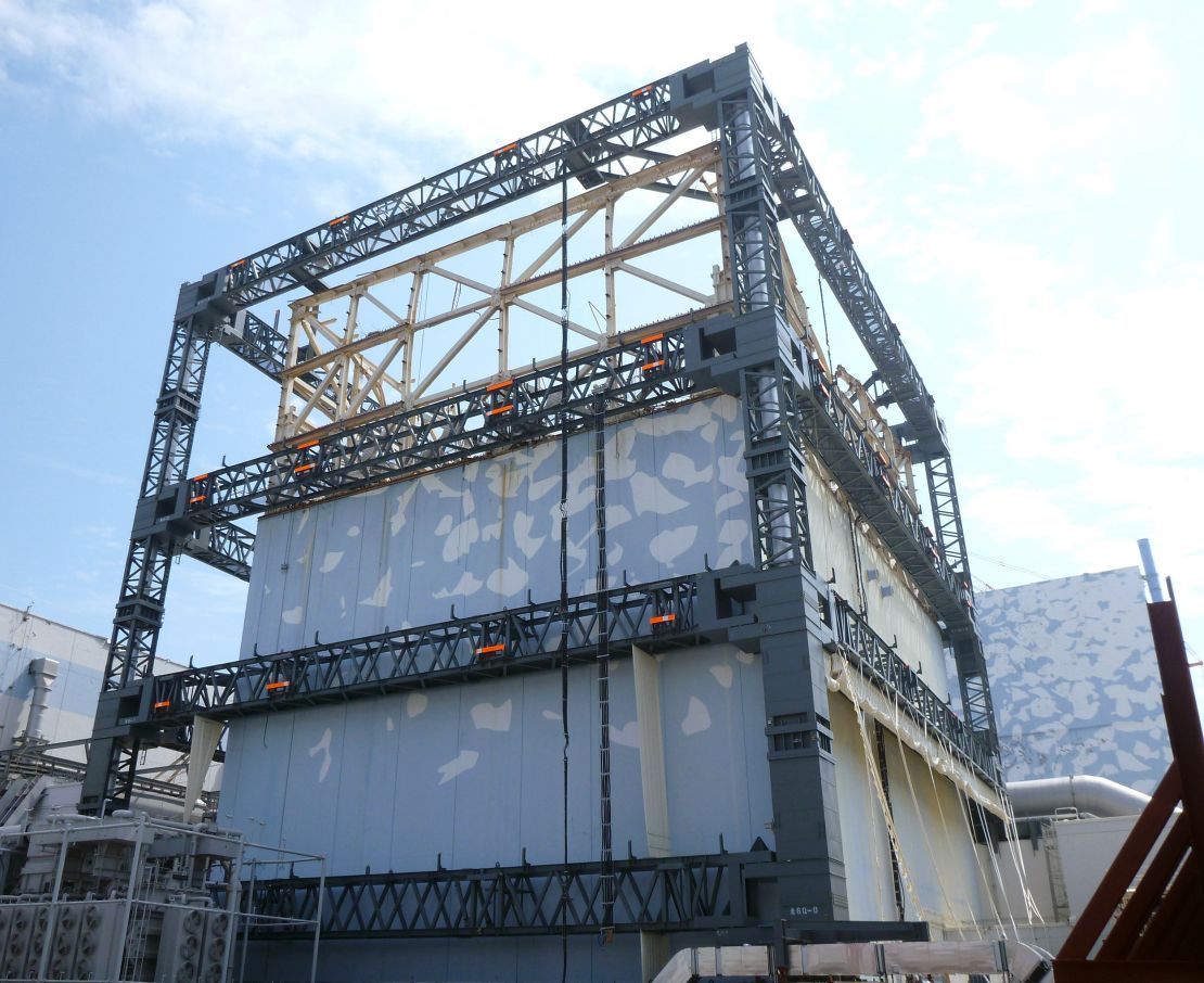 A Fukushima Daiichi reactor building is covered by a steel frame to prevent dispersal of radioactive materials.