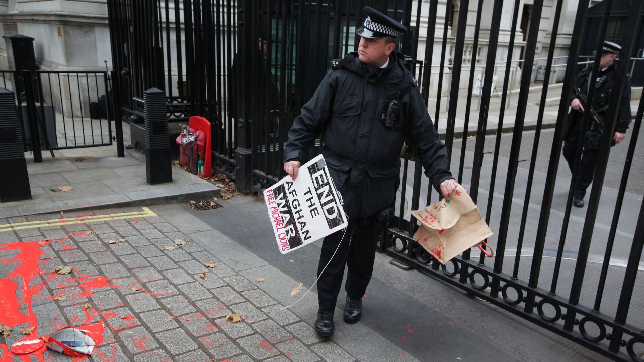 A policeman at Downing Street, London, clears away placards left by an anti-war protest on the 10-year anniversary. 