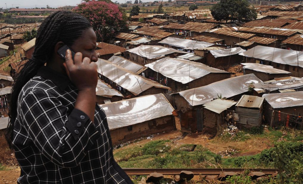 A woman speaks on a mobile phone in front of Kibera, one of the world's largest slums, on February 16, 2009, near Nairobi. Mobile phone growth in Africa has grown more than 400% from 2005 to 2010.
