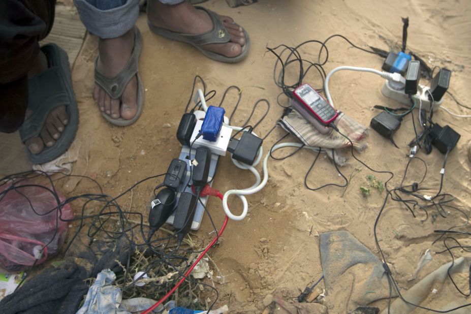Bengladeshi refugees from Libya recharge their cellular telephones on March 9 at the Choucha camp in Tunisia near the border with Libya. 