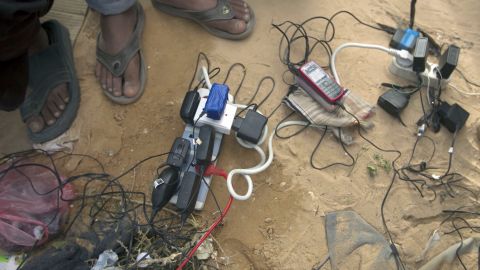 Bengladeshi refugees from Libya recharge their cellular telephones on March 9 at the Choucha camp in Tunisia near the border with Libya.