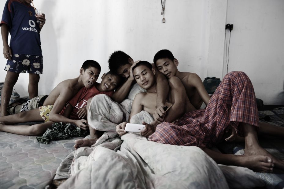 Thai orphans gather around watching videos on an iPhone at the Phuwana Muay Thai Kickboxing Camp on October 4, 2008, an hour outside of Bangkok. "Increased mobile connectivity in schools, as you can imagine, has had a profound effect," said economist Jeffrey Sachs.