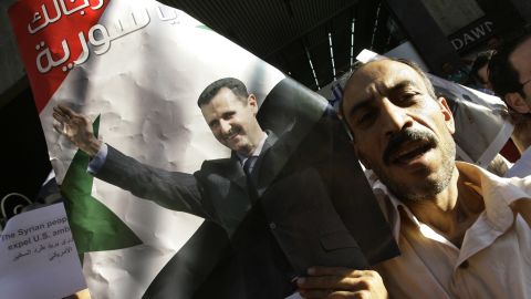 Syrians demonstrate in support of President Bashar al-Assad (poster) in central Damascus on August 23, 2011.