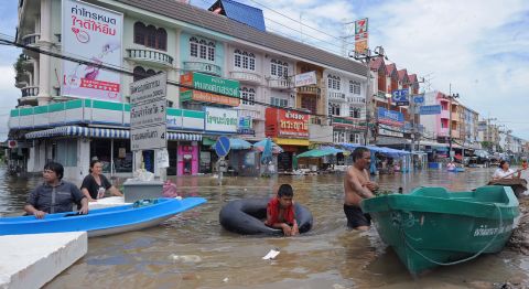 Thai residents stand in floodwaters along a street in the city of Ayutthaya on October 6, 2011. 