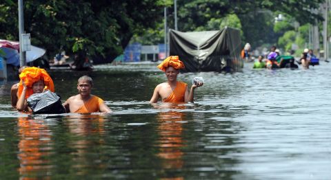 Buddhist monks walk through high water as floods inundate Ayutthaya province on October 10, 2011. 