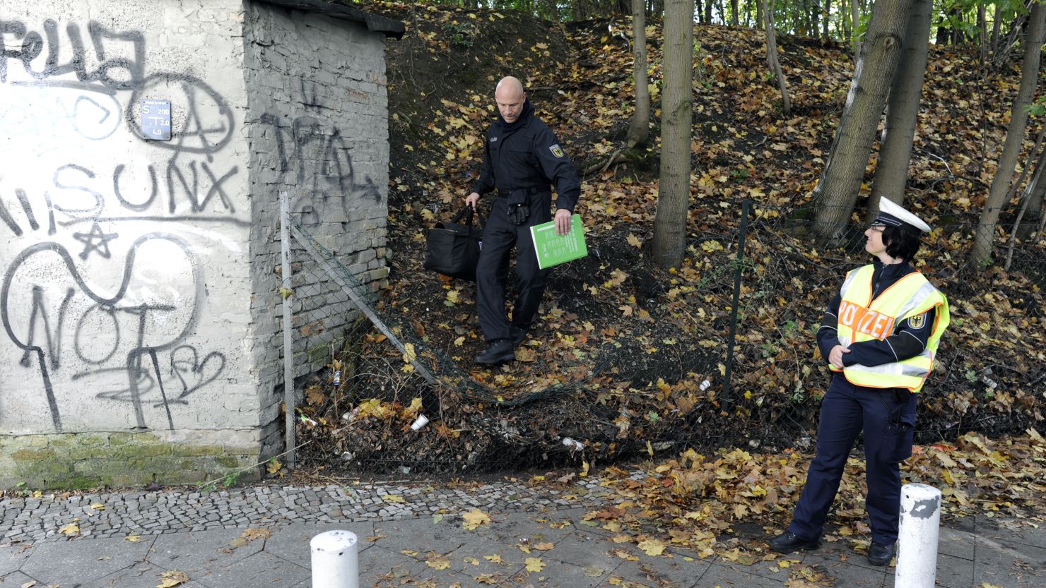 A policeman carries a bag after searching for evidence at a place where flammable devices were found.  