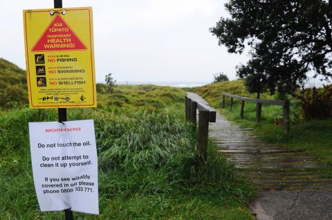 Warning signs are put up on Papamoa Beach on October 12 due to the health hazard posed by the oil spill.