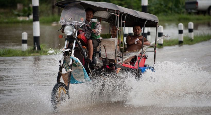 A tuk tuk (taxi) driver tries navigating the flooded streets in Ayutthaya on October 12, 2011. 