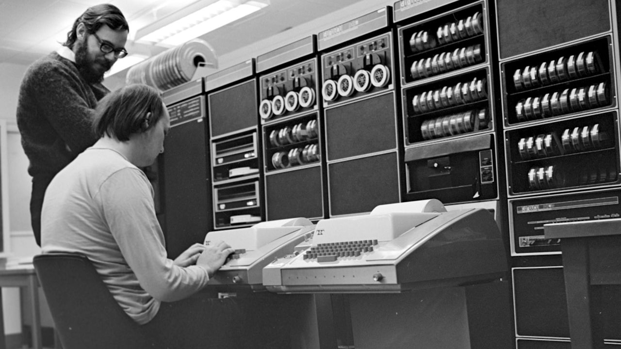Dennis Ritchie stands over Ken Thompson as he works on the PDP-11 in 1972. 