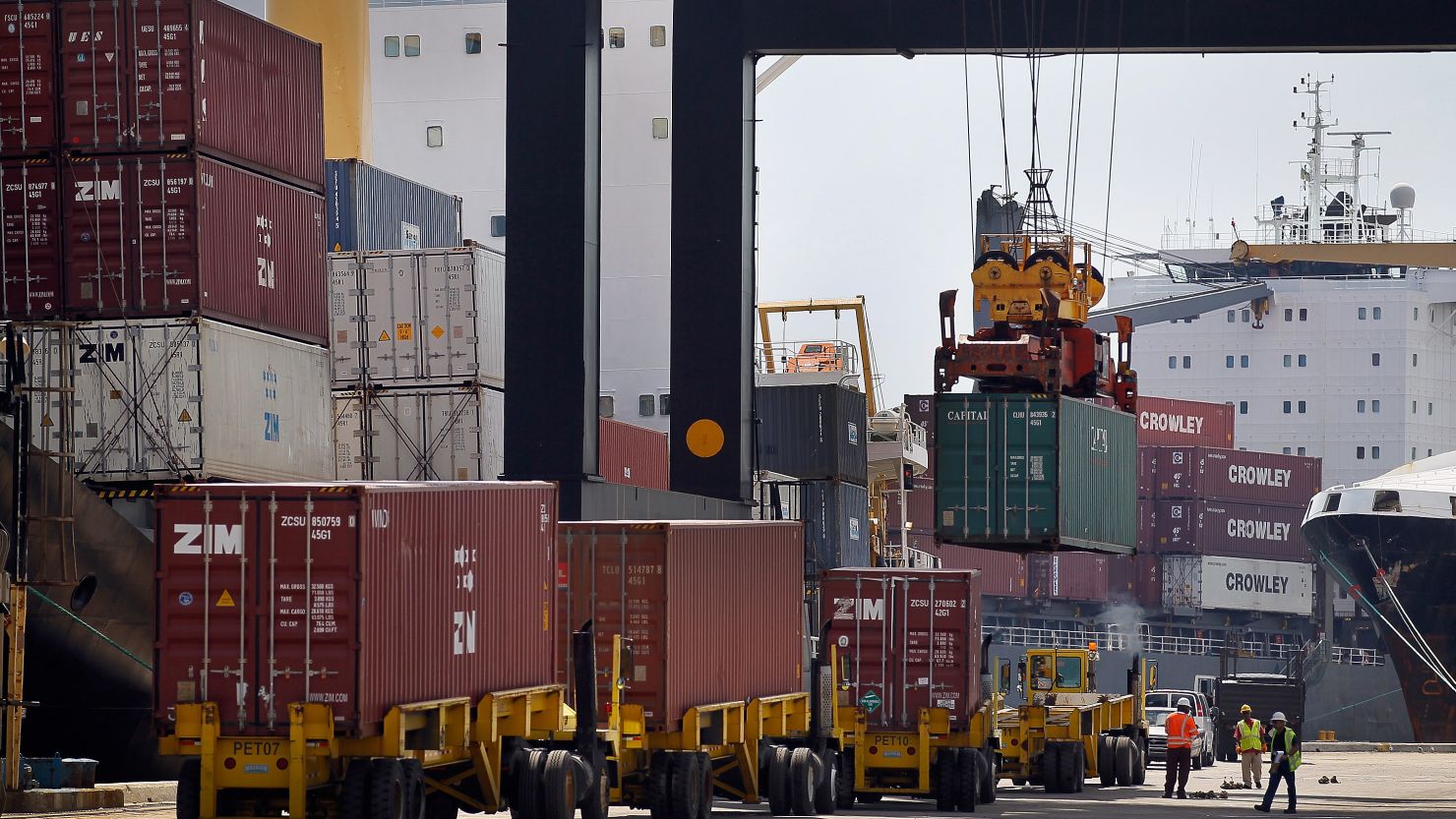 Longshoremen load shipping containers in Florida on Wednesday as lawmakers passed three free-trade agreements.