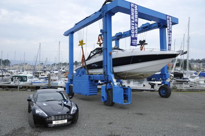 The "Quantum of Solace" Sunseeker hoisted up on a transporter with James Bond's favorite car, an Aston Martin, alongside.
