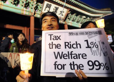 A protester in Seoul, South Korea, holds up a banner in front of the main gate of Deoksu palace on Saturday.