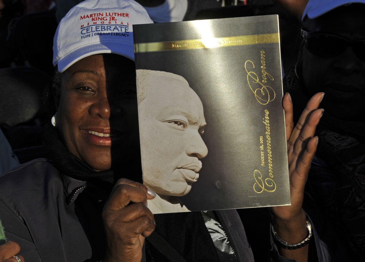 A woman in the crowd of spectators holds up the event brochure.