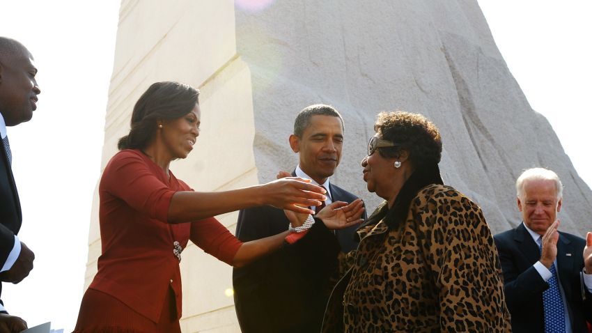 First Lady Michelle Obama reaches out to embrace Aretha Franklin as President and CEO of the Martin Luther King, Jr. National Memorial Project Foundation Harry Johnson (L), US President Barack Obama , Vice President Joe Biden (3rd R), Biden's wife Jill and Interior Secretary Ken Salazar (R) look on after Franklin performed at the dedication of the Martin Luther King Jr. Memorial October 16, 2011 in Washington, DC. AFP PHOTO/Mandel NGAN (Photo credit should read MANDEL NGAN/AFP/Getty Images)