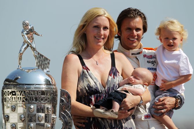 Wheldon holds his son Sebastian alongside his wife, Susie, and their son Oliver during the Indy 500 trophy presentation on May 30.