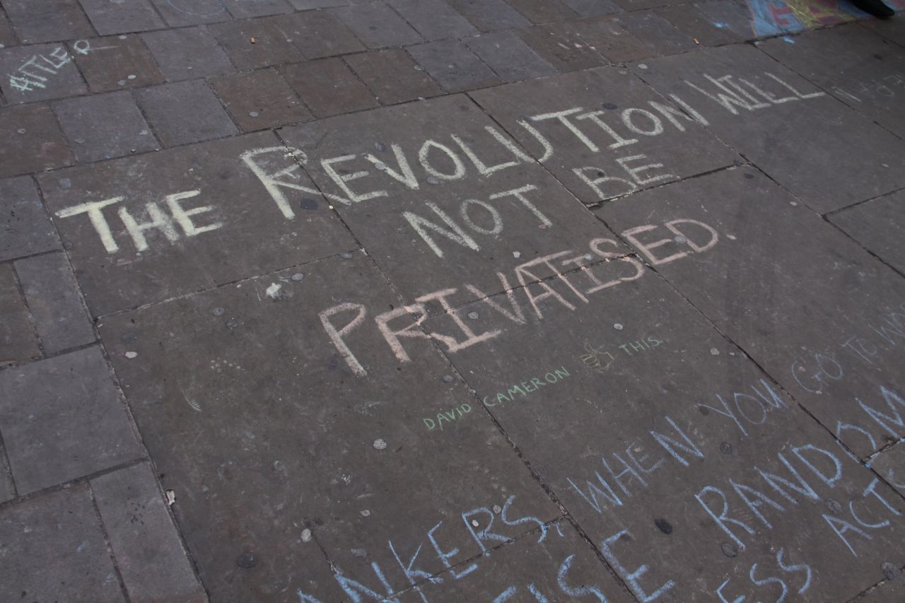 Chalk slogans cover the pavement near the tent village at St Paul's Cathedral.