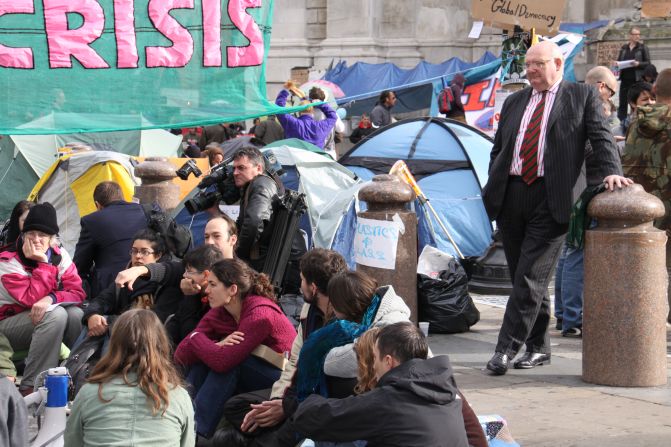A businessman listens in to Occupy London Stock Exchange protesters meeting outside St Paul's Cathedral