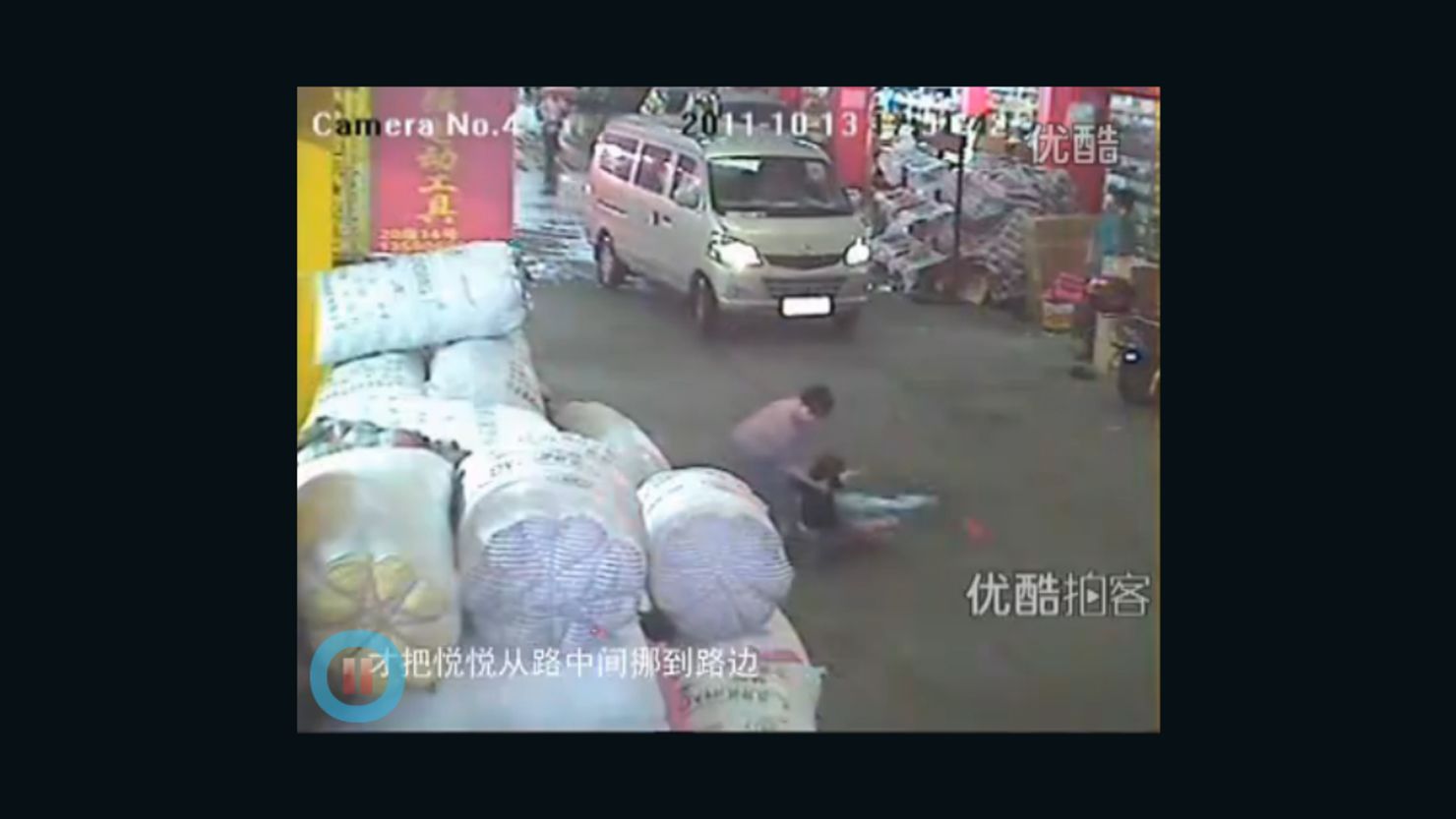 A screen grab of an incident on a China street where a toddler was run down shows a rescuer finally helping her