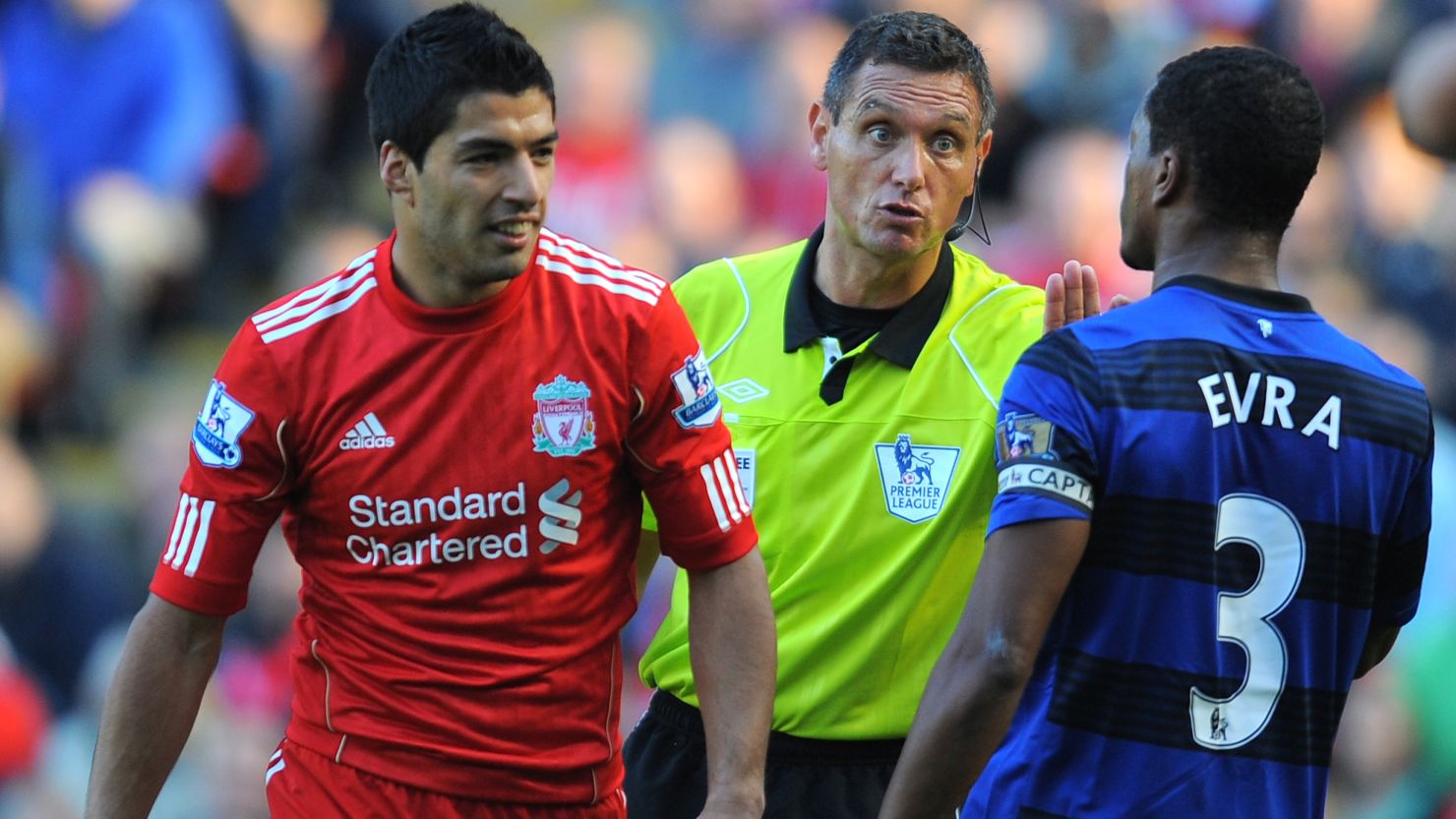 Referee Andre Marriner (C) talks to Liverpool's Luis Suarez (L) and Manchester United's Patrice Evra at Anfield on Saturday.