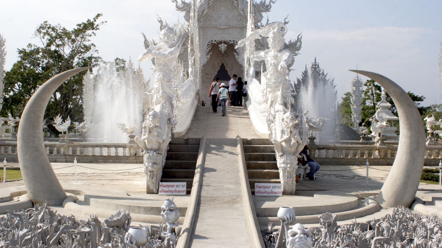 Visitors must cross a bridge to the Wat Rong Khun temple over a field of fangs and statues reaching up from hell.