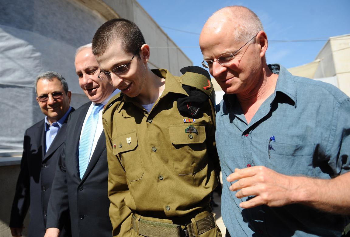 Israeli Defense Minister Ehud Barak, from left, Netanyahu, Gilad Shalit and his father, Noam Shalit, walk together at Tel Nof Airbase on Tuesday. Shalit was given medical checks that showed him to be in good health.