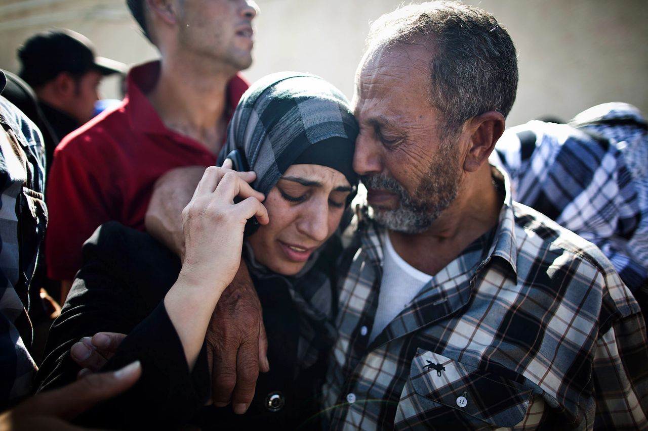 A Palestinian prisoner hugs relatives as she speaks on a mobile phone in Ramallah, West Bank, following her release on Tuesday.