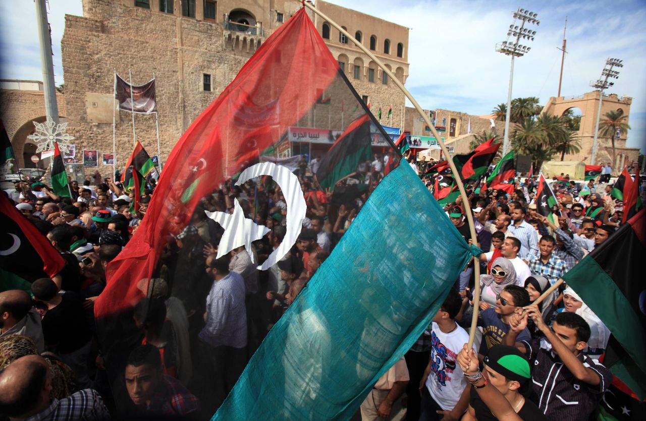 Libyans wave their new national flag as they celebrate in the streets of Tripoli after news of Gadhafi's capture.