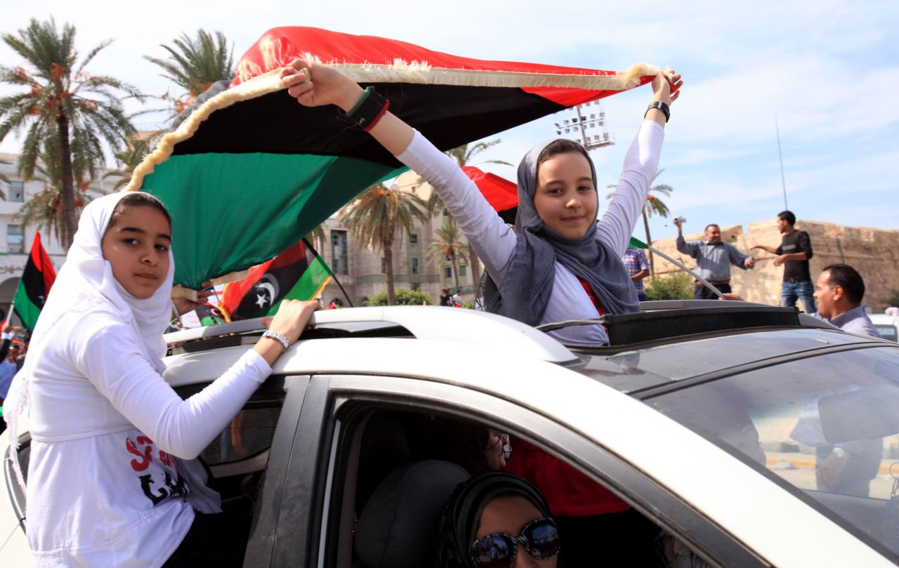 Young Libyan women celebrate with an NTC flag Thursday as they join others in the streets of Tripoli.