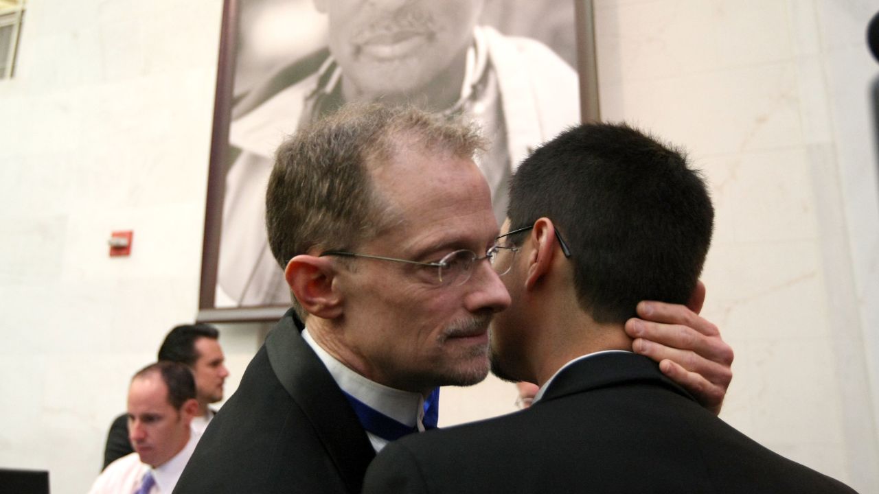 A couple embraces as they wait for a marriage license before getting married at San Francisco City Hall in 2008.