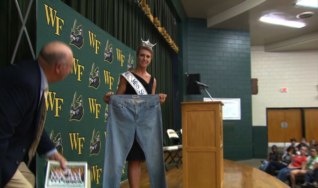 Bree Boyce, who is Miss South Carolina holds a pair of size 18 jeans she wore in high school. 