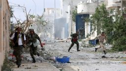 Libyan National Transitional Council (NTC) fighter run for cover during battles with loyalist troops on October 19, 2011 in Sirte's neighbourhood Number 2, one of the last two bastions of ousted leader Moamer Kadhafi's gunmen.