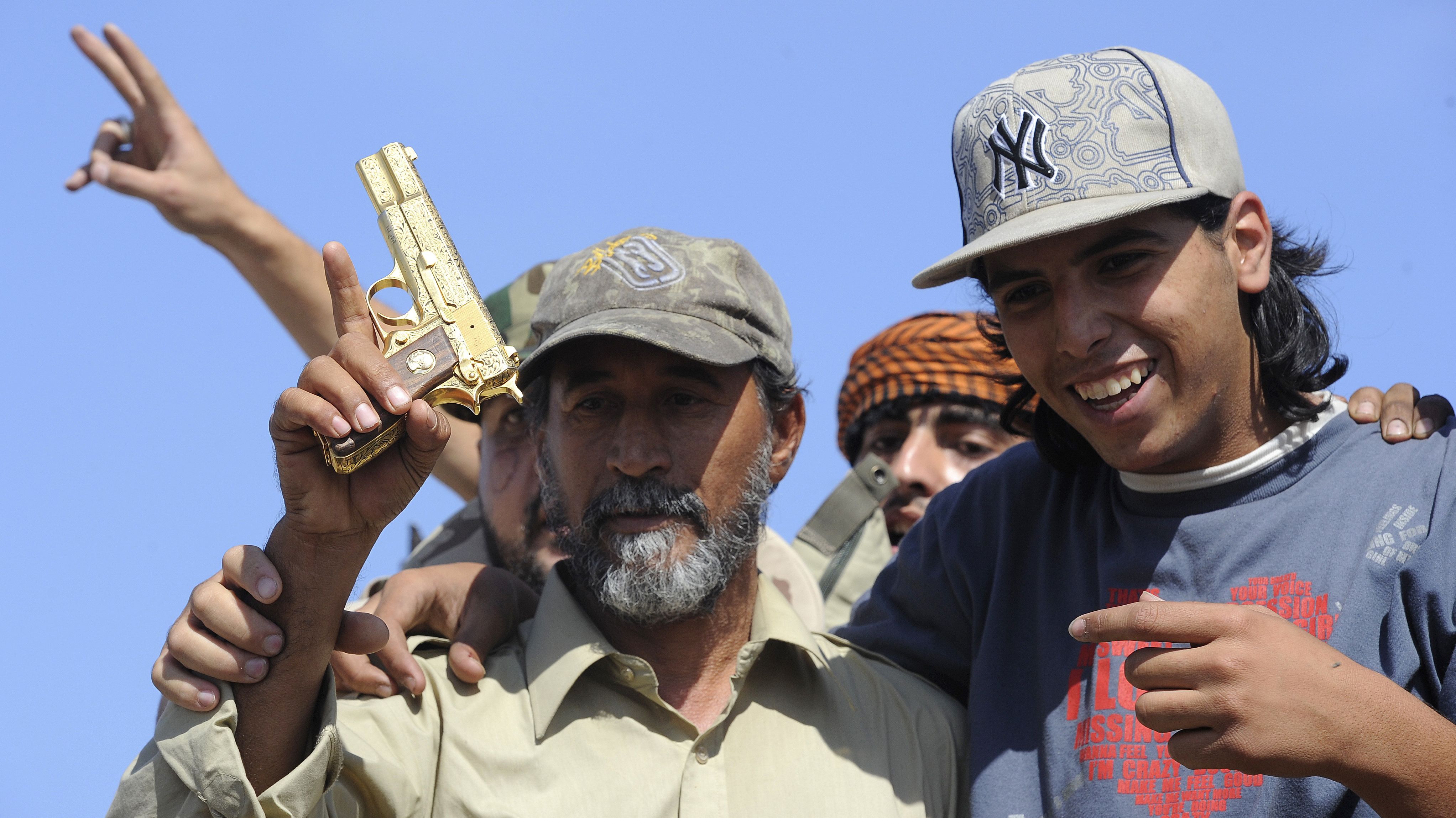 Anti-Gadhafi fighters hold what they say is the gold-plated gun of the ousted leader in Sirte, Libya, last week.
