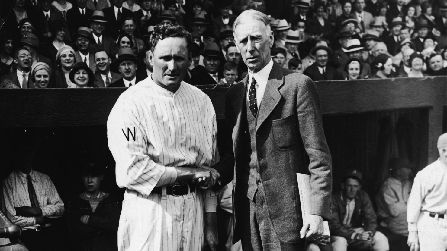 Wearing a suit, Philadelphia Athletics manager Connie Mack greets Walter Johnson, pitcher for the Washington Senators, in 1910.