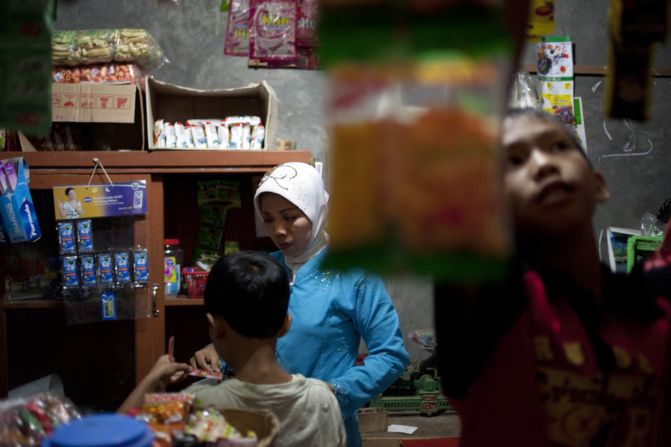 Mutmanah Witono, 38, worked for nine years in Singapore. She returned home to set up a small shop beside her house in Central Java, says Sim.