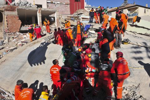 Turkish rescue workers try to recover people from a collapsed building in Ercis on Monday.
